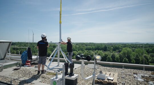 Två anställda på ett tak installerar ett fast nätverk 
