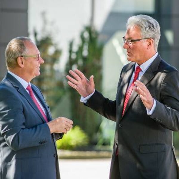 Two businessmen talking to each other