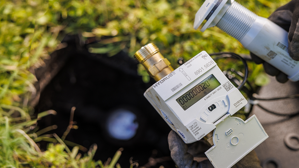 Picture of Diehl Metering  water meter HYDRUS 2.0 residential and a  IZAR STELLA radio/MIU in the hand of US utility operator