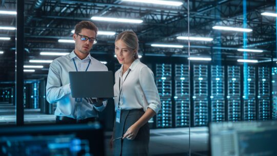 un homme et une femme un ordinateur à la main dans une salle des machines