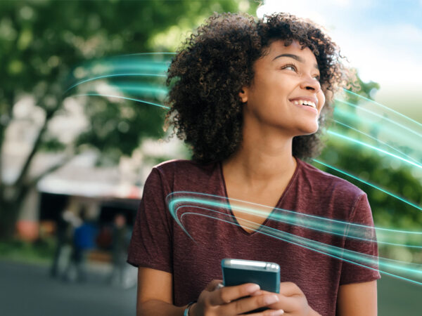 A person  from Diehl Metering happy smiliing with a smartphone and new diehl metering brand design signature “Flowline"